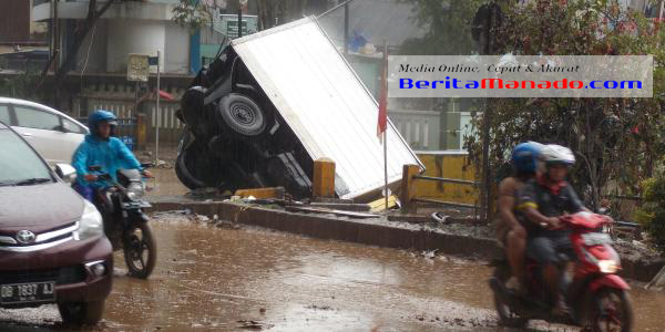 Kendaraan yang terbawa arus akibat banjir di Manado