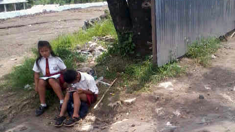 Dua siswa SD korban bencana harus belajar di pinggir jalan (foto beritamanado) 