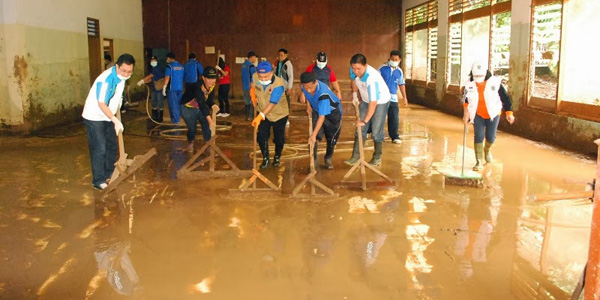 Para anggota Korpri saat membersihkan sekolah yang tergenang lumpur