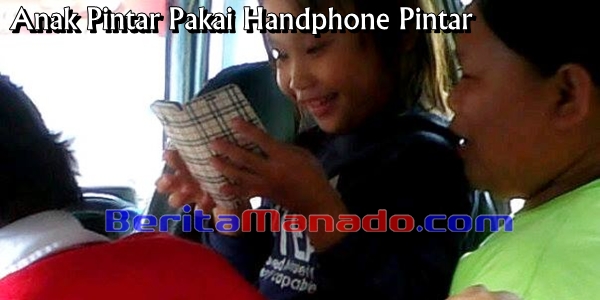Seorang Bocah Perempuan Nampak Asyik Dengan Smartphonenya 