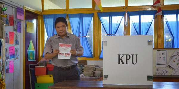 Kabag Humas Sulut DR Jimmy Kumendong saat melakukan pencoblosan di TPS 14 Kampung Baru