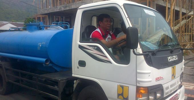 Plt Direktur PAM Novi Tampi saat mengemudi mobil tangki untuk menyuplai air minum ke masyarakat