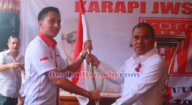 Bupati Minahasa Drs Jantje Wowiling Sajow MSi saat memberikan bendera Merah Putih kepada Ketua Karapi JWS Langowan Raya Deryan Saerang
