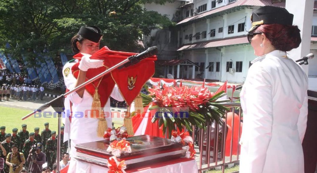 Bupati Minut Vonnie Panambunan menyerahkan bendera merah putih untuk dikibarkan.