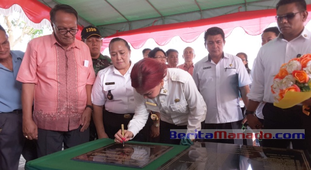 Bupati Vonnie Panambunan menandatangani prasasti peresmian gedung MCK dan prasasti nama-nama Hukum Tua Desa Watudambo.