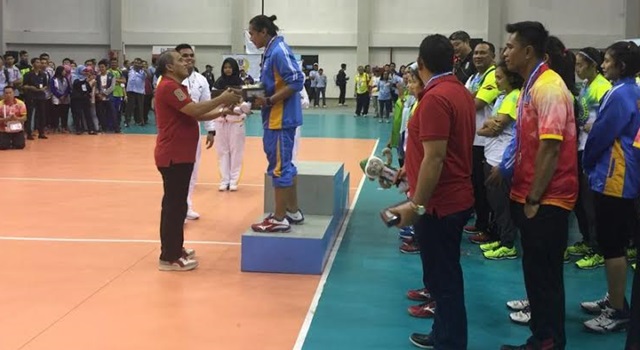 Manajer Tim Drs Jantje Wowiling Sajow MSi saat menyerahkan medali kepada salah satu pemain andalan Aprilia Manganang