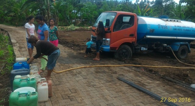Masyarakat sedang menampung air bersih dari kendaraan tangki air yang didatangkan satgas TMMD Kodim 1309/Manado