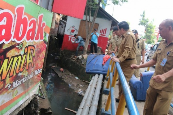 Wakil Walikota Manado, MOR D. BASTIAAN, didampingi Camat Tuminting, SONNY TAKUMANSANG, saat melihat kondisi saluran air yang mulai dangkal dan dipenuhi sampah.