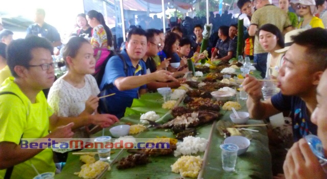 Para turis sangat menikmati makanan khas Minahasa.