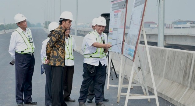 Presiden Joko Widodo sedang memperhatikan penjelasan percepatan pembangunan jalan Tol