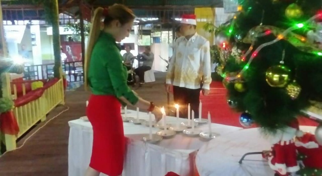 Wakil Ketua DPRD Minut Shintya Rumumpe menyalakan lilin natal.