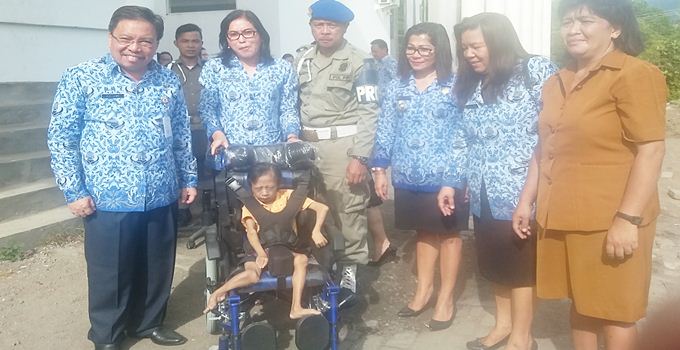 Sekda Farry Liwe menyerahkan bantuan kursi roda dari ketua TP PKK Propinsi kepada Vicky Ponomban penyandang disabilitas