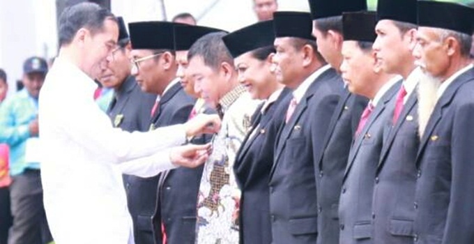 Presiden Jokowi menyamatkan tanda penghargaan kepada Bupati James Sumendap