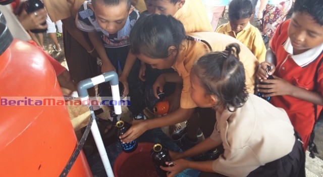 Anak didik SD Inpres Kampung Ambong menikmati air minum gratis.