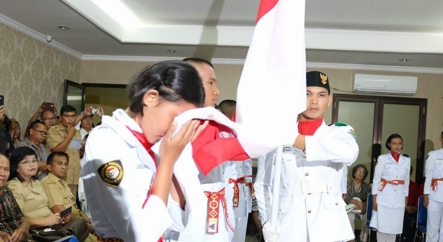 Paskibraka Minut mencium bendera, dalam proses pengukuhan.(foto: Staf Khusus Bupati Minut)