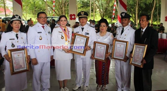 Camat Talawaan Johan Wewengkang bersama sejumlah hukum tua menerima penghargaan dari Bupati Vonnie Panambunan dan Wabup Joppi Lengkong.
