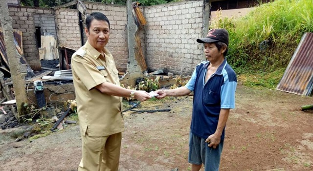 Ivan Sarundajang saat meneyrahkan bantuan kepada korban bencana kebakaran rumah Maxi Mamuaja