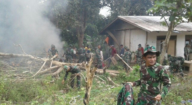 SEMANGAT: Prajurit TNI gotong royong membersihkan desa.(foto: Kodim 1310/Btiung)