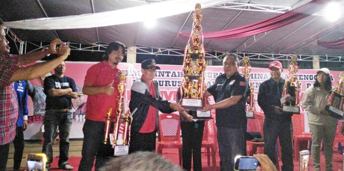 Camat Berty Mokat menyerahkan hadiah kepada pemenang lomba koor gaya KNPI Silian Raya
