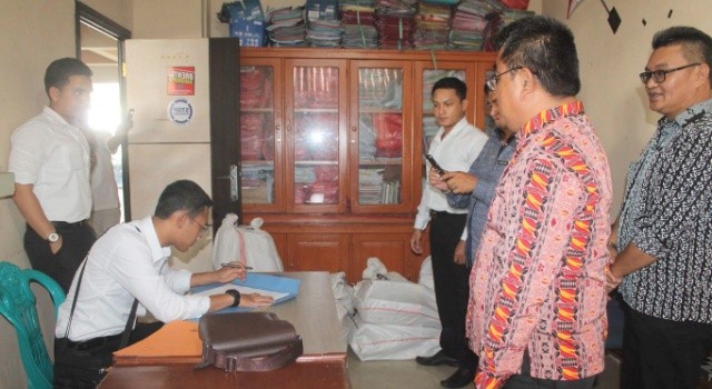Kanit Tipikor Ipda Chandra Buana STK menandatangani berita acara penyerahan berkas bersama Kepala Inspektorat Minut Umbase Mayuntu. 