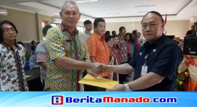 Sekda Minut Ir Jemmy Kuhu MA menyerahkan SK Pelantikan Pengurus LPPD Minut kepada Ketua Harian Rivino Dondokambey.