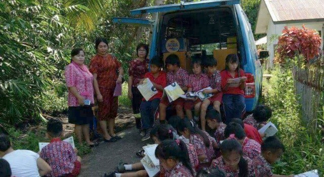Siswa SD Inpres Kokole Kecamatan Likupang Selatan membaca di perpustakaan keliling.