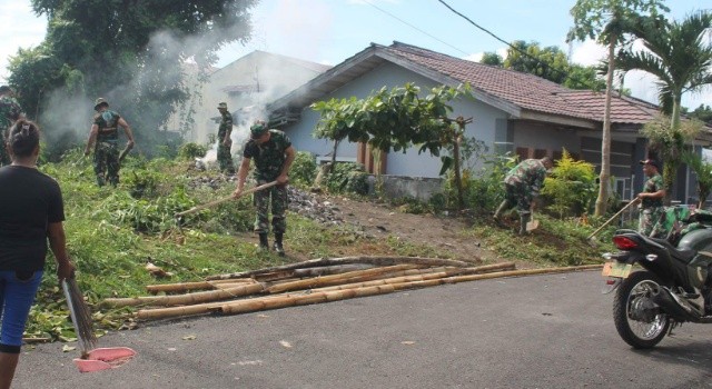 Para Prajurit Koramil 1310-06 Airmadidi saat sedang membersihkan bidang pekarangan kosong di Desa Kolongan Tetempangan.
