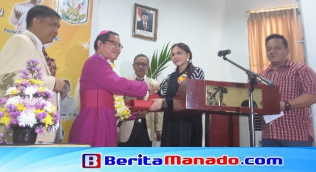 Bupati Vonnie Panambunan membuka kegiatan dan menyumbangkan uang tunai kepada panitia dan peserta yang diterima Uskup Manado Mgr Benedictus Untu.