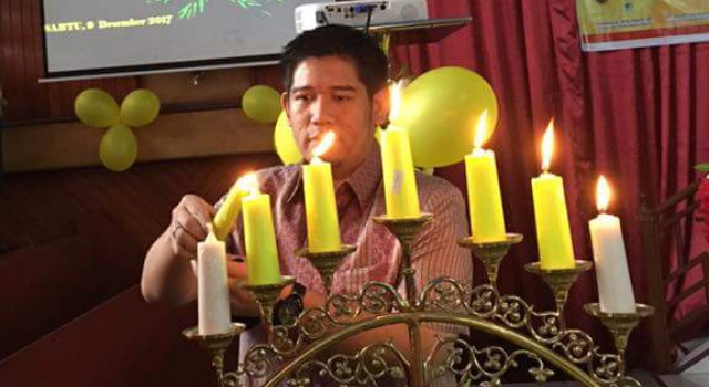 Wakil Ketua DPD I Partai Golkar Sulut, Rizky Mokodompit menyalakan lilin Natal.