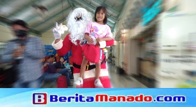 Santa Clauss bagi-bagi hadiah kepada anak-anak di Bandara Sam Ratulangi Manado
