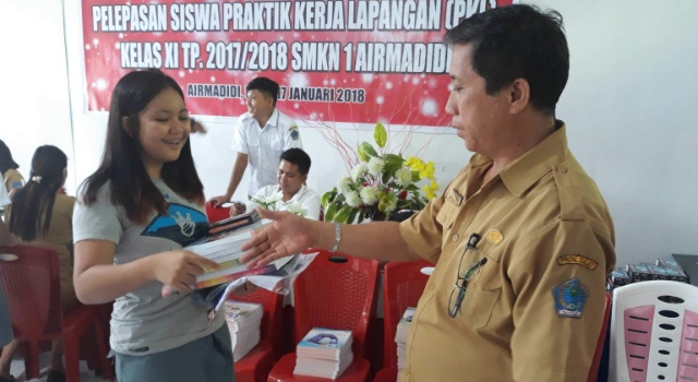 Kepala Sekolah SMKN 1 Airmadidi Weddy Onibala menyerahkan bantuan kepada siswa.