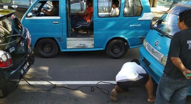 Foto yang sedang viral di Facebook, seorang driver taxol membantu menderek mikrolet yang mogok