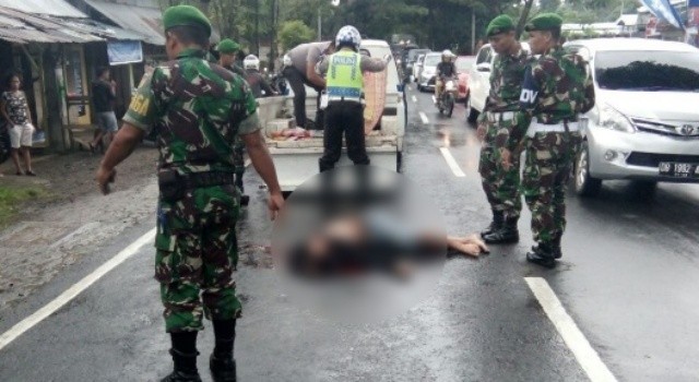 Petugas Sat Lantas Polres Minut dibantu personel TNI, mengevakuasi korban.