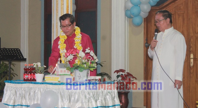 Uskup Manado Mgr. Benediktus Estephanus Rolly Untu saat memasang lilin kue ulang tahun