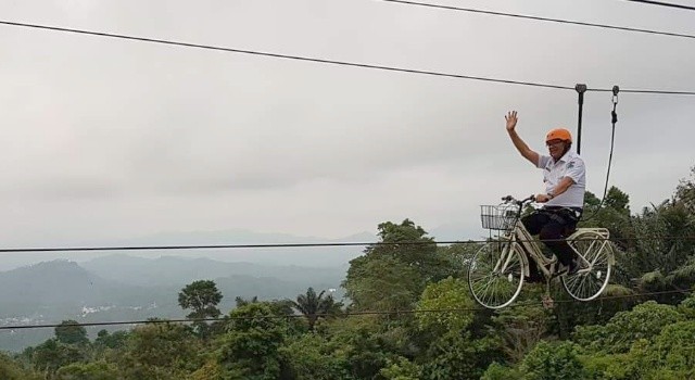 Wabup Minut Joppi Lengkong mencoba wahana sepeda gantung.