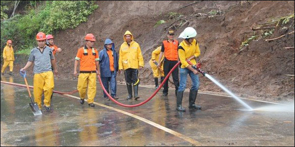 Petugas BPBD Kota Tomohon tak kenal lelah membersihkan jalur utama Tomohon-Manado.