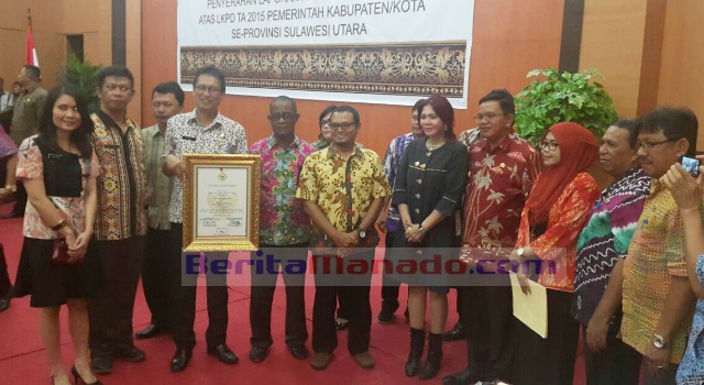 Kepala BPKBMD Robby Parengkuan, memegang piagam penghargaan WTP bersama Bupati, Wabup dan sejumlah pejabat Pemkab Minut.