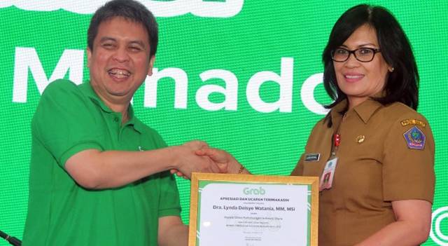 Ridzki Kramadibrata, Managing Director Grab Indonesia memberikan sertifikat penghargaan kepada Dra. Lynda Deisye Watania, MM, MSi., selaku Kepala Dinas Perhubungan Provinsi Sulawesi Utara.