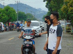 Sejumlah Pemuda Turun ke Jalan, Bagi Masker dan Semprot Disinfektan Kendaraan Yang Melintas