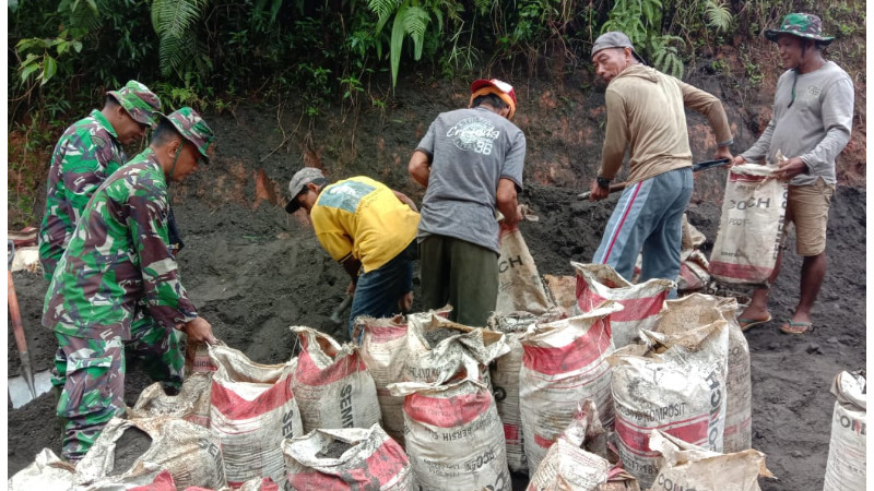 Hadapi Medan Berat, Satgas TMMM Dibantu Warga Angkat Material Pakai Karung