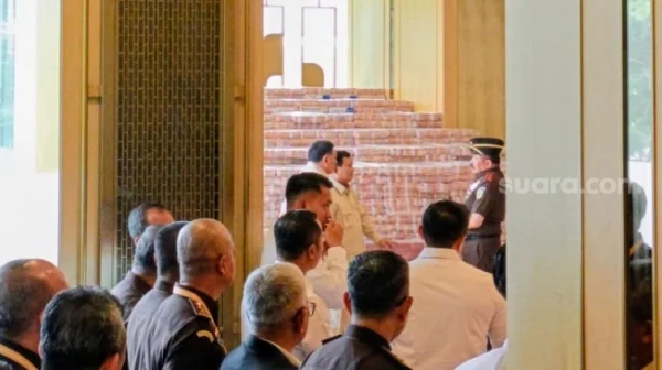 Presiden Prabowo Subianto bersama Jaksa Agung Sanitiar Burhanuddin tampak berbincang-bincang di depan tumpukan uang senilai Rp13,2 triliun lebih di Kejaksaan Agung. (Suara.com/Novian)