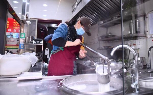 Seorang staf membuat mi beras Shengzha di sebuah restoran di Wilayah Otonom Etnis Yao Dahua yang berada di Kota Hechi, Daerah Otonom Etnis Zhuang Guangxi, China selatan, pada 21 Maret 2026. (Xinhua/Huang Xiaobang)