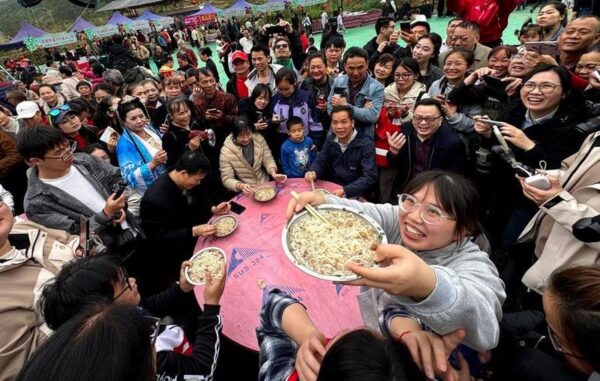 Warga mengikuti lomba makan mi dalam sebuah ajang kompetisi keahlian warisan budaya takbenda di Wilayah Otonom Etnis Yao Dahua yang berada di Kota Hechi, Daerah Otonom Etnis Zhuang Guangxi, China selatan, pada 21 Maret 2026. (Xinhua/Huang Xiaobang)