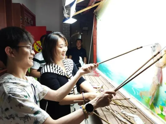 Mahasiswa Indonesia Soroti Kebijakan Pengembangan Teknologi Futuristik dan Revitalisasi Pedesaan di China 9 Foto yang diabadikan pada 21 Mei 2025 ini menunjukkan Nathaniel Hartono Putra (kiri), mahasiswa Indonesia yang menempuh pendidikan di Universitas Shanxi, sedang mengunjungi sebuah desa di Provinsi Shanxi, China utara, dan menjajal kesenian wayang kulit lokal. (Xinhua/Xie Yuan)