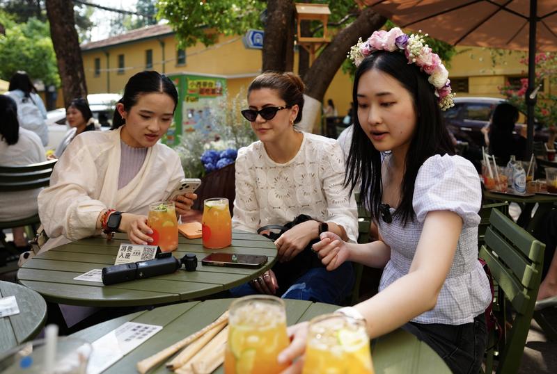 Blogger Tionghoa-Amerika Zhu Xirui, atau Sherry Zhu (kiri), dan saudari-saudarinya mencicipi minuman teh dan kopi modern di Jalan Huanggongdong di tepi Danau Cuihu di Kunming, Provinsi Yunnan, China barat daya, pada 24 April 2026. (Xinhua/Chen Xinbo)