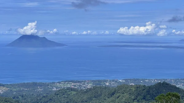 Berita Manado Hari Ini: BBM Nonsubsidi, Agotey, dan Rano Tilaar 1 Pemandangan Teluk Manado dari Puncak Agotey di Kecamatan Mandolang, Kabupaten Minahasa dengan laut biru, perbukitan hijau, dan langit cerah.