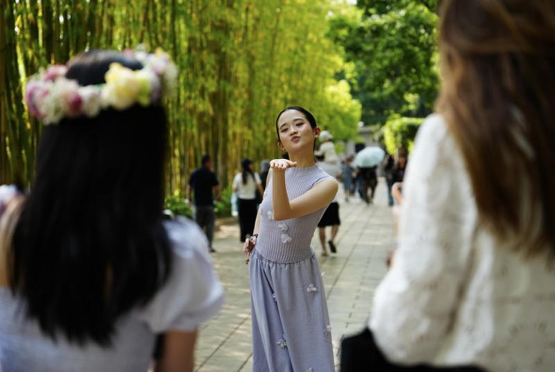 Blogger Tionghoa-Amerika Zhu Xirui, atau Sherry Zhu (tengah), berpose untuk difoto di Taman Cuihu di Kunming, Provinsi Yunnan, China barat daya, pada 24 April 2026. (Xinhua/Chen Xinbo)