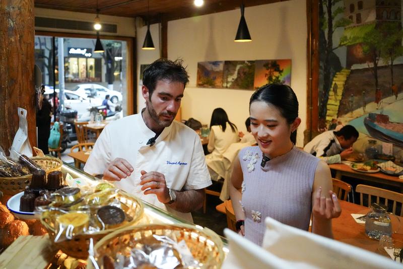 Blogger Tionghoa-Amerika Zhu Xirui, atau Sherry Zhu (kanan), berbincang dengan koki asal Prancis, Vincent, di restorannya di Kunming, Provinsi Yunnan, China barat daya, pada 24 April 2026. (Xinhua/Chen Xinbo)