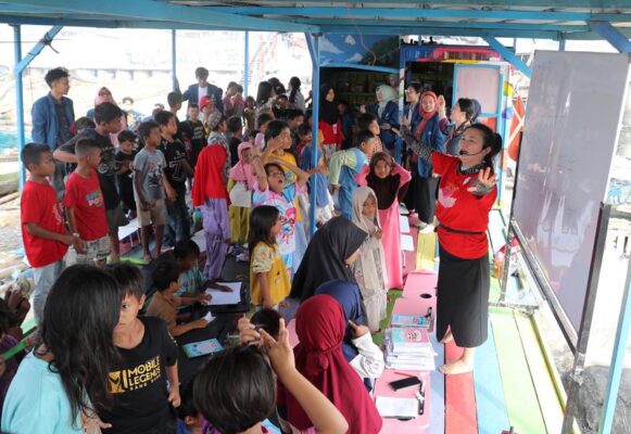 Chai Yinhui (kedua dari kanan) mengajar bahasa Mandarin kepada anak-anak di sebuah gubuk beratap seng sederhana di tepi pantai di Jakarta Utara pada 9 Mei 2026 (Xinhua/Ceng Yunpeng)
