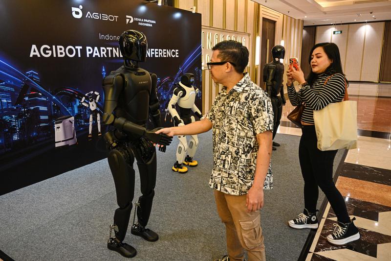 Seorang pengunjung berinteraksi dengan robot humanoid dalam Konferensi Mitra AGIBOT Indonesia (AGIBOT Partner Conference Indonesia) 2026 di Jakarta pada 9 Juni 2026. (Xinhua/Agung Kuncahya B.)